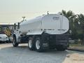 A 2016 Freightliner M2 106 fuel tanker truck with a white cylindrical tank and a black chassis parked with its rear visible