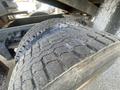 Close-up of a worn tire from a 1997 Freightliner FL70 showing notable tread wear and visible cracks in the rubber surface