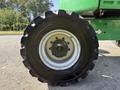 Close-up of a wheel from a 2015 JLG 450AJ with a rugged tire tread pattern and a central hub featuring a circular bolt pattern