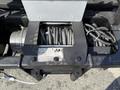 A close-up view of a winch mounted on a 2015 Ford F-550 with visible steel cables and control mechanisms