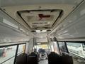 Interior view of a 2021 Ford Econoline showing the ceiling emergency exit sign and front dashboard with driver seats positioned in the foreground