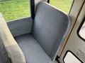 Interior view of a single gray seat in a 2013 International 4300 bus with a textured fabric and a simple design