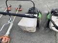 Three Honda Lawnboy mowers and two Stihl line trimmers placed side by side on a flat surface
