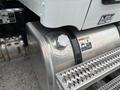 A close-up of the fuel tank of a 2025 Peterbilt 536 with a cap and warning labels visible on the surface
