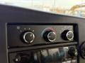 The dashboard control panel of a 2017 Chevrolet Express featuring three circular knobs for temperature and fan control with a digital clock display