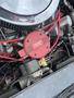 Close-up of a 1970 Chevrolet Corvette engine showing a red Holley ignition coil alongside various wires and components