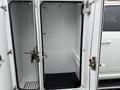 A white 2024 RAM 5500 truck with an open utility box featuring two doors and empty interior space