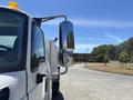 A 2008 International DuraStar truck with a chrome side mirror and an orange light on the roof