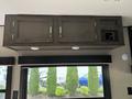 A modern overhead cabinet with two doors and metallic handles designed for a 2021 Jayco Jay Flight camper interior