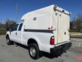 A 2016 Ford F-250 SD white pickup truck with a custom shell on the bed and a rear-mounted door