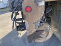 A close-up of the rear of a 2014 International 7400 showing a red light a metal plate and various hoses and connectors attached to the vehicle