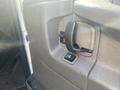 Close-up of the door handle and window control of a 2011 Chevrolet Express van with a textured black interior panel