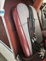 Close-up of a red and gray upholstered airplane seat with safety straps attached to a maroon and white aircraft interior
