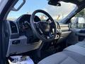 Interior view of a 2020 Ford F-350 showing the steering wheel dashboard and front seats in a light gray fabric