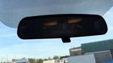 A 2019 Nissan Kicks rearview mirror reflecting the interior of the car with a darkened view