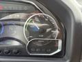 A close-up of a vehicle's dashboard showing a gauge indicating regenerative energy usage with a blue and green dial and an ecoLion logo