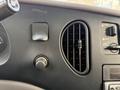 Dashboard controls and air vent of a 2002 Ford Econoline with a circular vent and various knobs and buttons for vehicle settings