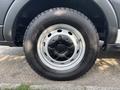 A close-up of a 2016 Ford Transit 150 wheel showing a silver rim and a black tire with visible tread patterns