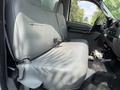 Interior view of a 2007 Ford F-450 showing a gray bench seat in the front cabin with a steering wheel and dashboard visible