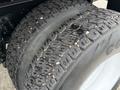A close-up view of a 2012 International 7400 tire showing its tread pattern with visible wear and gravel embedded in the grooves