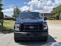 A blue 2015 Ford F-150 facing the viewer with a prominent front grille and headlights