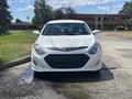 A white 2014 Hyundai Sonata facing forward with a sleek design and a prominent black grille