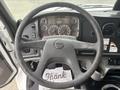 Interior view of a 2006 Freightliner M2 106 dashboard with a steering wheel and instrument panel featuring gauges and controls