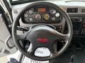 A 2020 Peterbilt 330 steering wheel with various gauges and controls visible on the dashboard