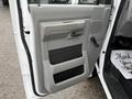 A 2019 Ford Econoline door panel featuring a light gray finish with a handle and storage compartments