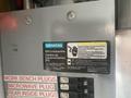 A Siemens electrical load center with various circuit breakers and labels including warnings and instructions for use and safety