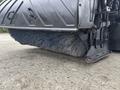 A close-up of a large street sweeper brush attached to a 2013 International DuraStar 4300 showing bristles used for cleaning road surfaces