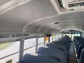 Interior of a 2006 Thomas Saf-T-Liner HDX school bus featuring rows of blue seats and overhead signage indicating emergency exits