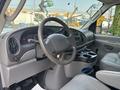 Interior of a 2008 Ford Econoline showing the steering wheel dashboard and center console with cup holders