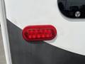 Close-up of a red LED trailer tail light on a 2013 Outdoor Wind River with a white and gray exterior