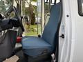 A blue fabric seat inside a 2002 Ford Econoline van with a steering wheel and dashboard visible