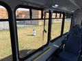 A 2017 Chevrolet Express with large windows and blue fabric seats visible in the interior