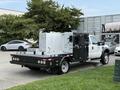 A white 2008 Ford F-450 SD with a flatbed and equipment storage boxes mounted on the back
