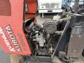 Close-up of a 2015 Kubota F3990 tractor engine showcasing intricate components including hoses valves and a round air filter