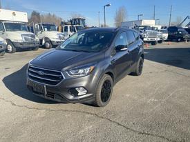 A 2019 Ford Escape in gray with black rims and a sleek design is parked on a concrete surface