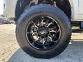 Close-up of a black alloy wheel on a 2018 RAM 3500 featuring aggressive tread design and bold lettering on the tire