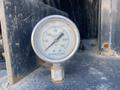 A pressure gauge displaying readings with a dial marked in PSI and labeled Green Line