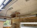 Interior view of a 2008 Ford Econoline with wooden shelves and a clean, unfinished interior design