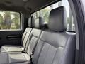 The interior backseat of a 2011 Ford F-350 SD featuring gray leather upholstery and three headrests