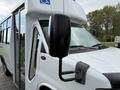 A white 2013 Chevrolet Express front view showing the side mirror and door with a partially open window