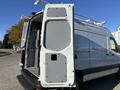 A 2024 Mercedes-Benz Sprinter 2500 van with open rear doors displaying a spacious cargo area and a clear panel on the left side