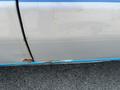 A 2005 Ford Econoline with visible rust and paint damage on the side panel