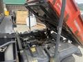 A 2011 Kubota RTV 1140 CPX with its cargo bed raised revealing the engine compartment and various components underneath