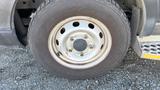 Close-up of a wheel on a 2021 Ford Transit showing a silver rim with six lug nut holes and a black tire with tread pattern visible
