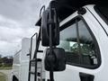 Close-up of the side mirror and door of a 2021 Freightliner M2 106 with a black and white color scheme