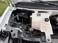 A 2004 Chevrolet Express with the hood open displaying the engine compartment including the battery coolant reservoir and various engine components